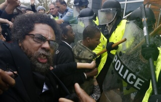 Activist Cornel West is knocked over during a scuffle with police during a protest at the Ferguson Police Department in Ferguson, Missouri, Oct. 13, 2014. (Jim Young/Reuters)