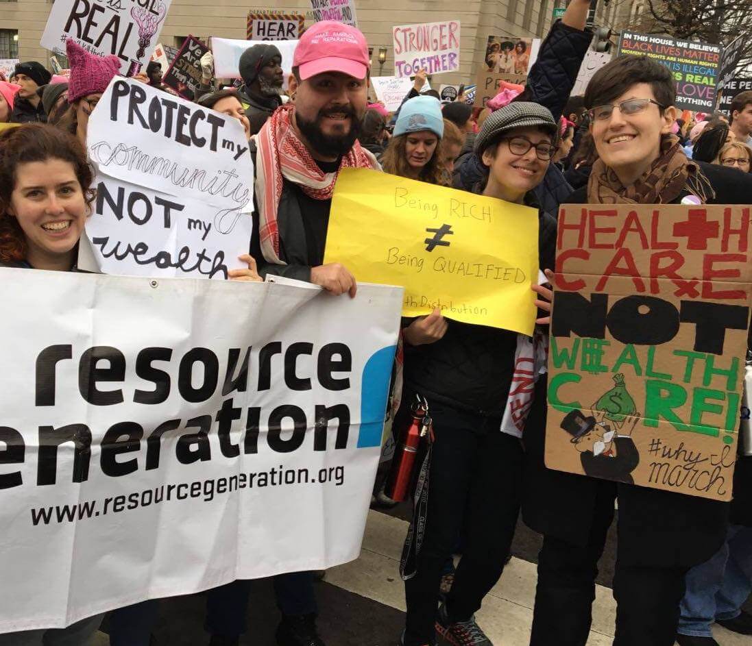 Resource Generation members at a protest holding signs and Resource Generation banner